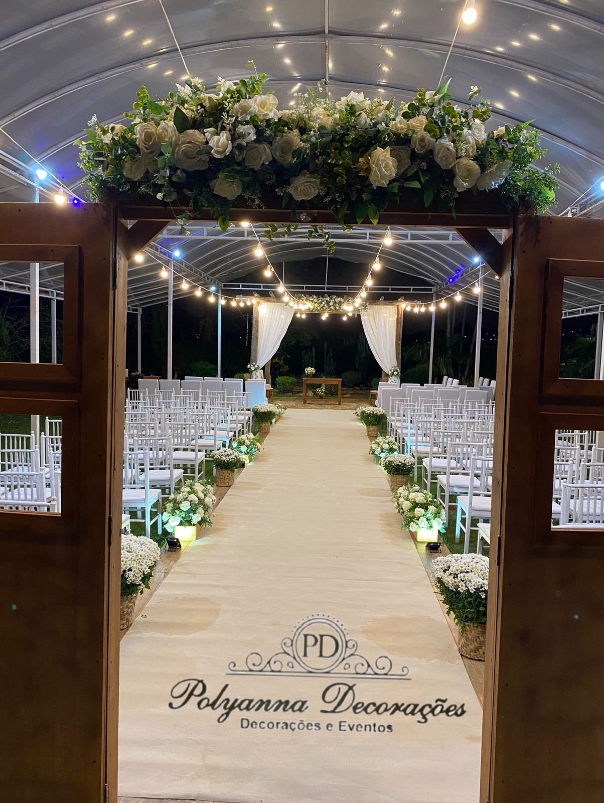Passarela com porta de Entrada, decoração no gazebo do espaço com 1 floreiras e tecidos e aparador rústico, carpete, caminho de Bola belga e buxinhas nas caixinhas ripadas e rústicas